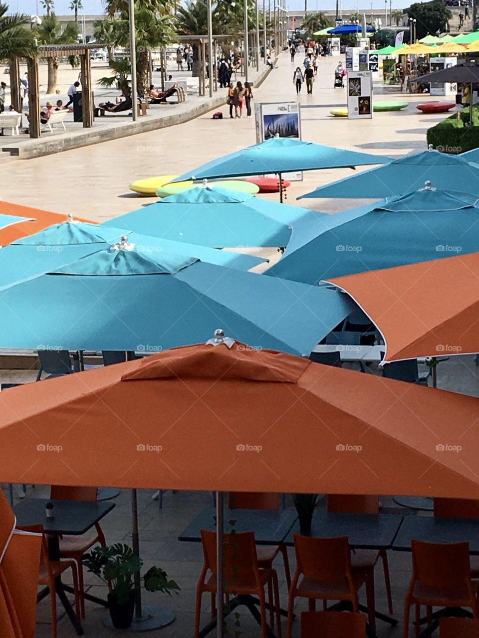 Blue and Orange parasols on pier