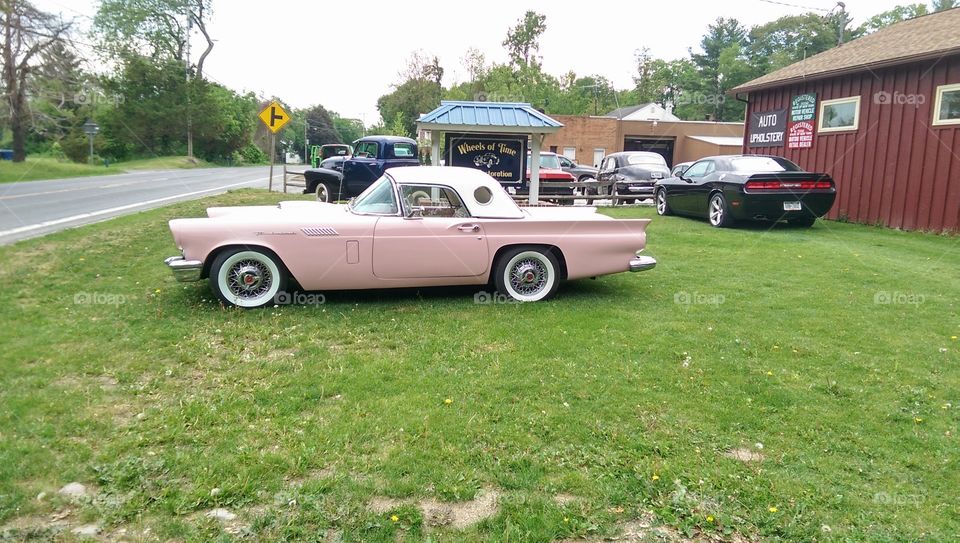 Pink classic car. Parked outside a custom car restoration shop