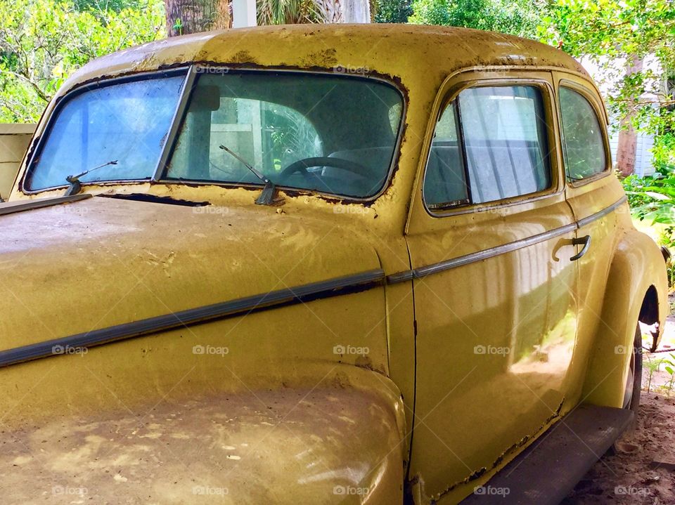 Old antique car yellow Packard rusted and dirty