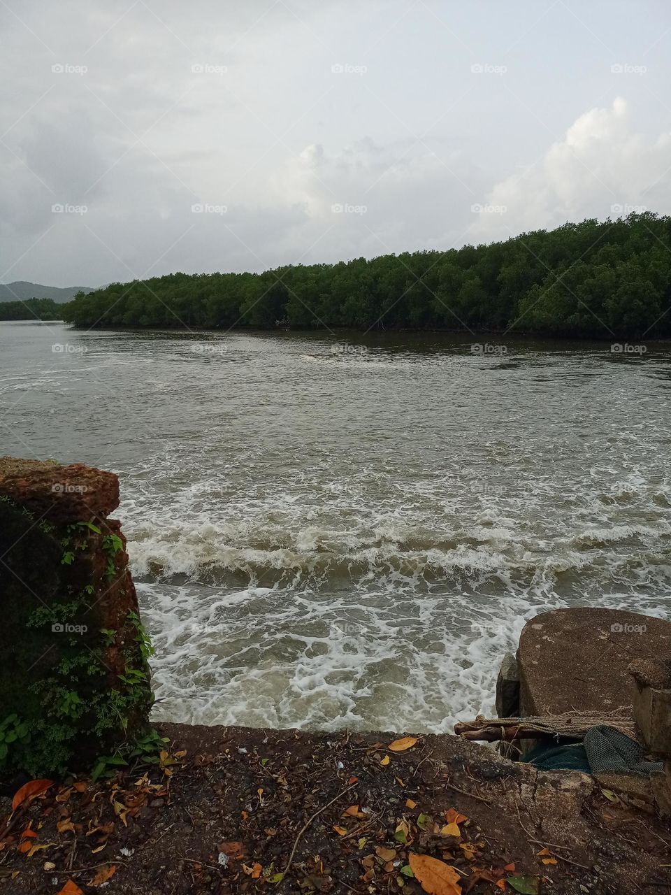 Beautiful view of the river middle of the bridge pillar it's looking nice sunset time background of mountain