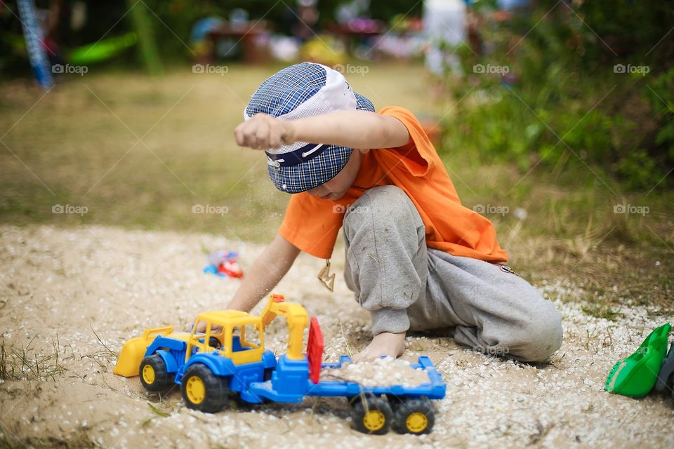Boy playing with toys in a sandbox