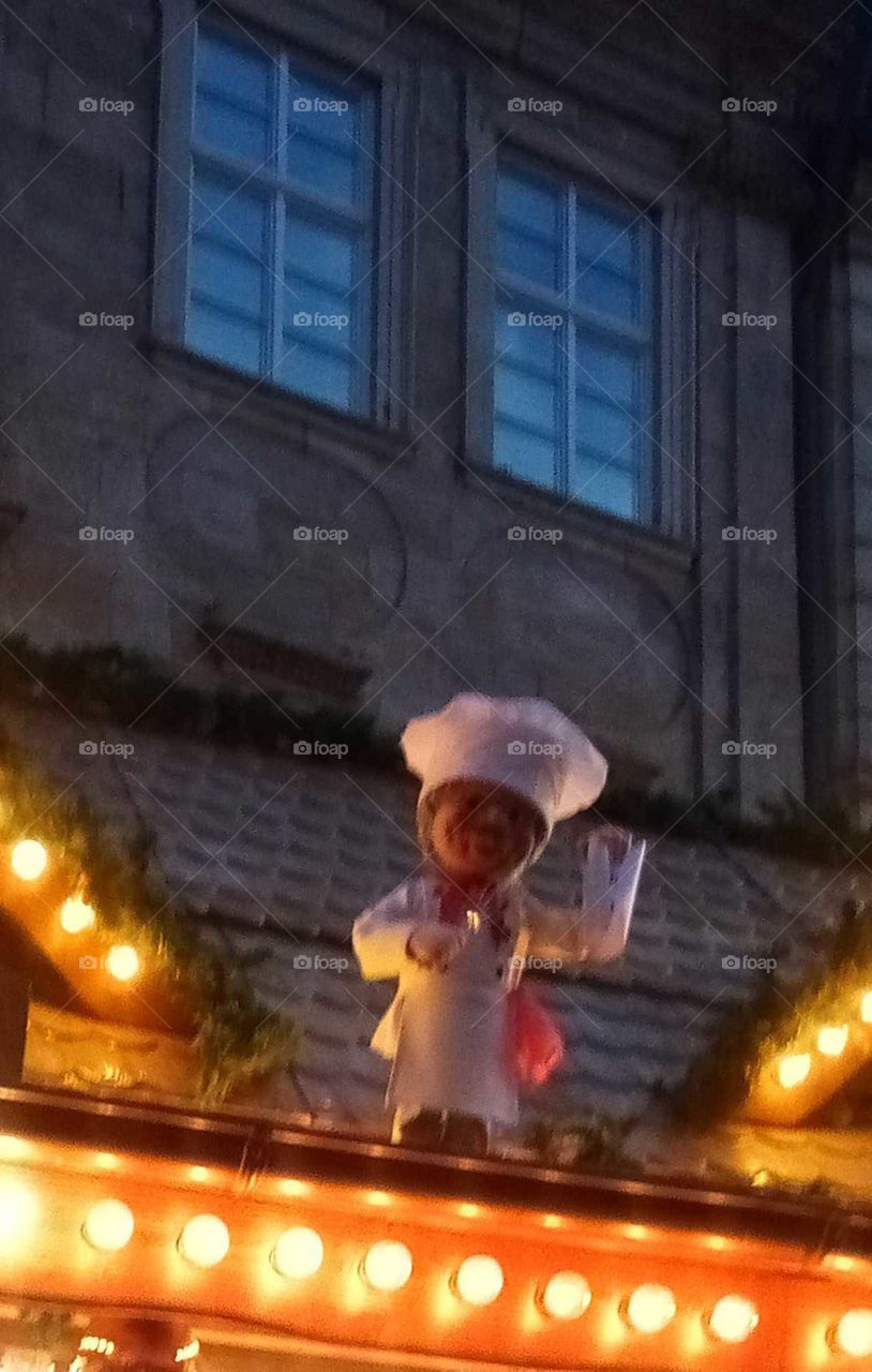vom Dach einer Weihnachtsbude winkt eine lustige Figur ,