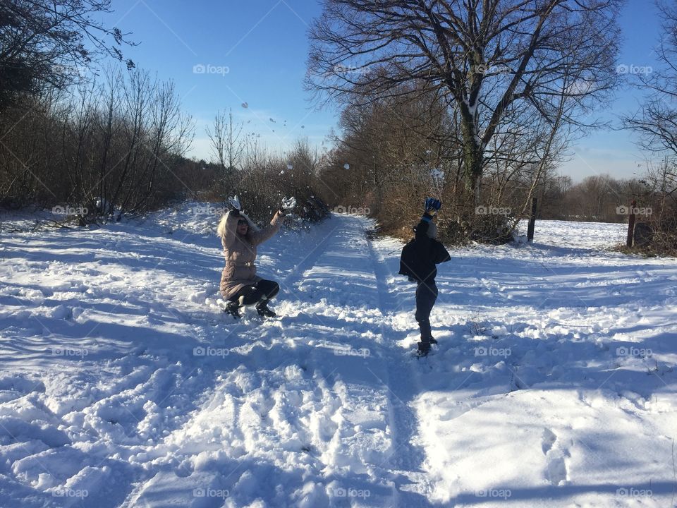 Mother and child enjoying on snowy landscape
