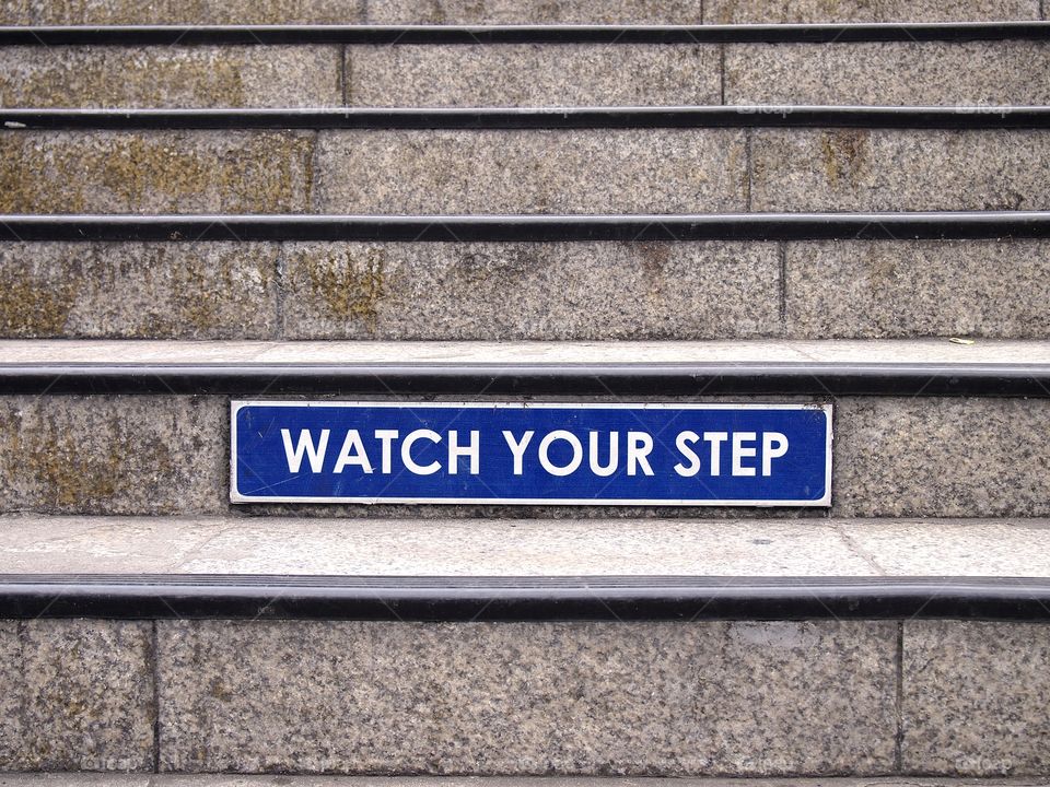 watch your step sign on a set of staircase