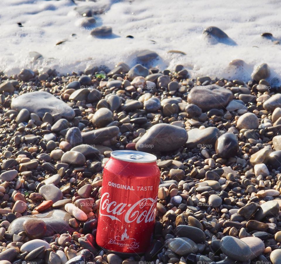 A can of Coca Cola on the beach.