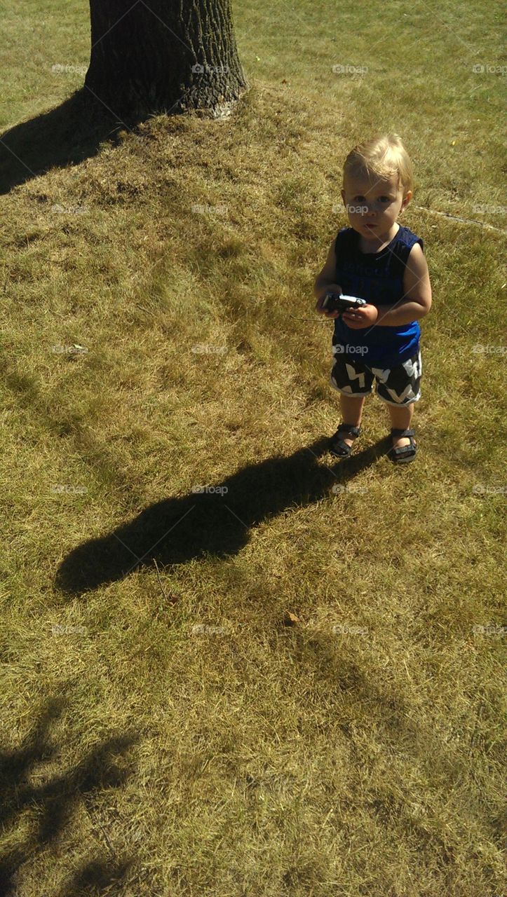 A toddler boy with his car and shadow