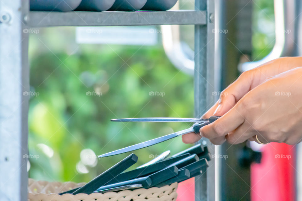 The hand holding the steak knives and knife cut a lot in the basket.