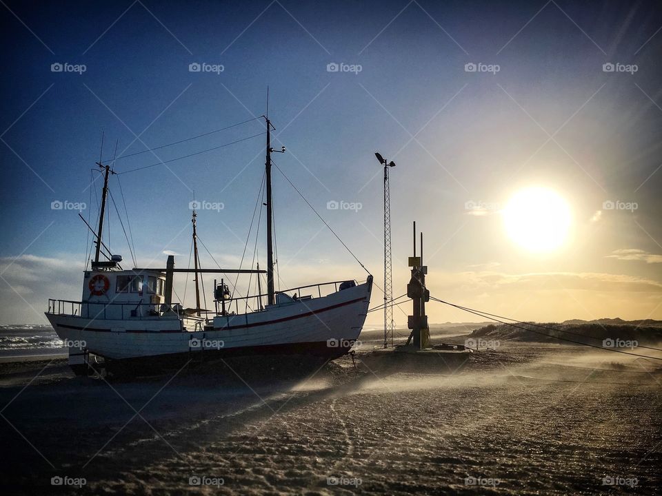 Fishing boat on the danish westcoast. The fisherman pulls his boat up on the beach.