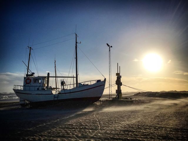 Fishing boat on the danish westcoast. The fisherman pulls his boat up on the beach.