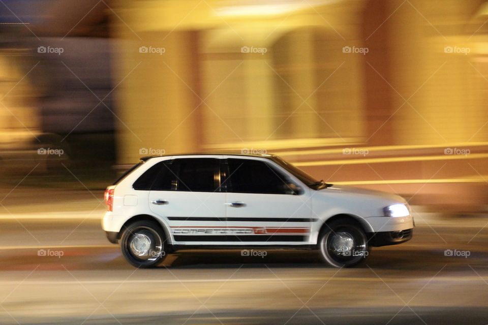 Fast car at night. White car. Panning photography. 