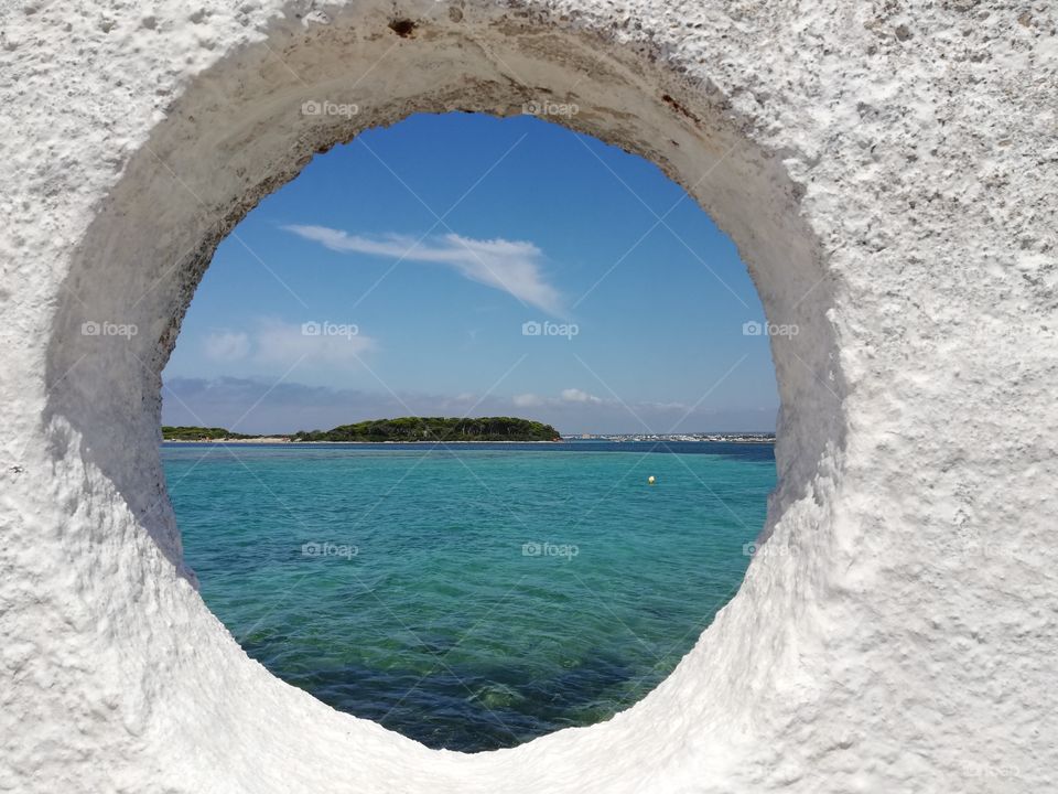 crystal clear sea of ​​Puglia(Italy)seen from a round window