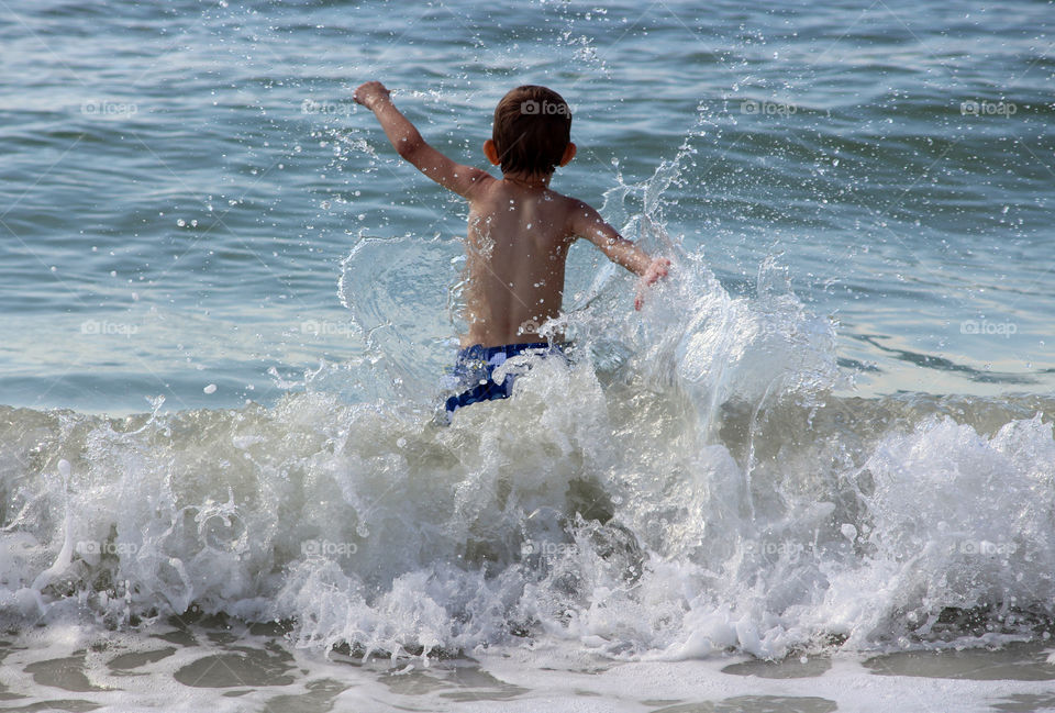 Rear view of boy enjoying beach