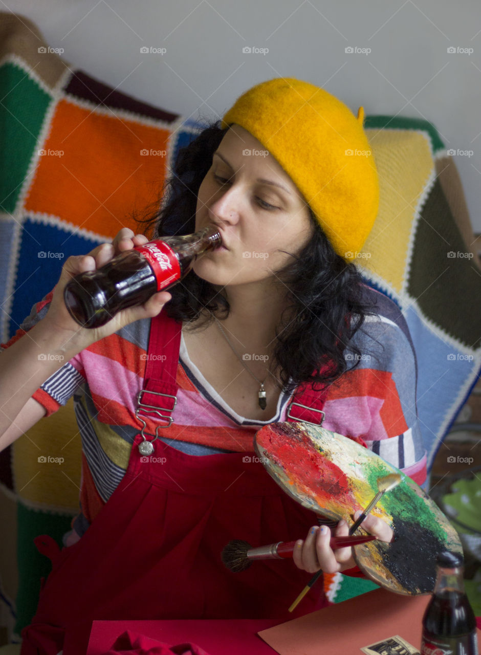 A woman artist drinking Coca-Cola from the bottle