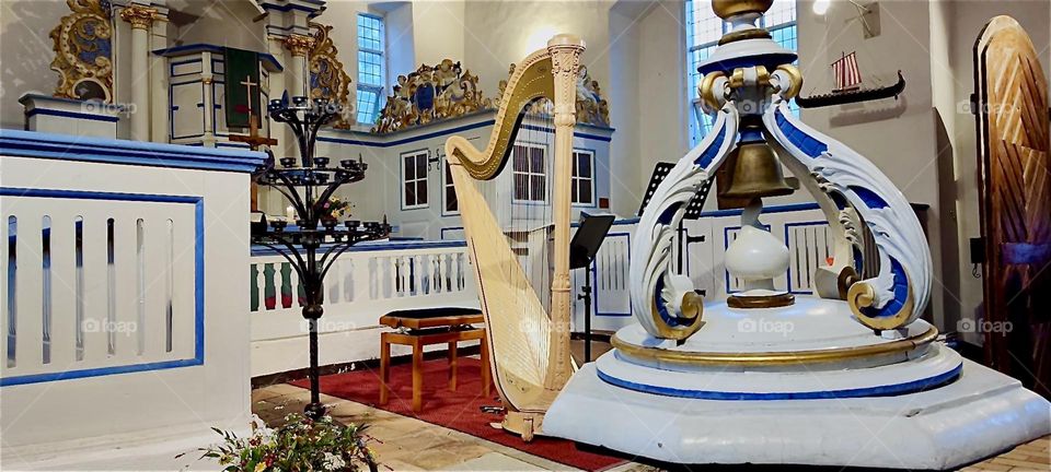 This is the lavishly decorated interior including an oversized harp of the “Inselkirche”, the “Island Church” on the island “Hiddensee” in the “Baltic Sea” or “Ostsee” in “Mecklenburg - Western Pomerania”, Germany. 2024. Hypnotic Productions
