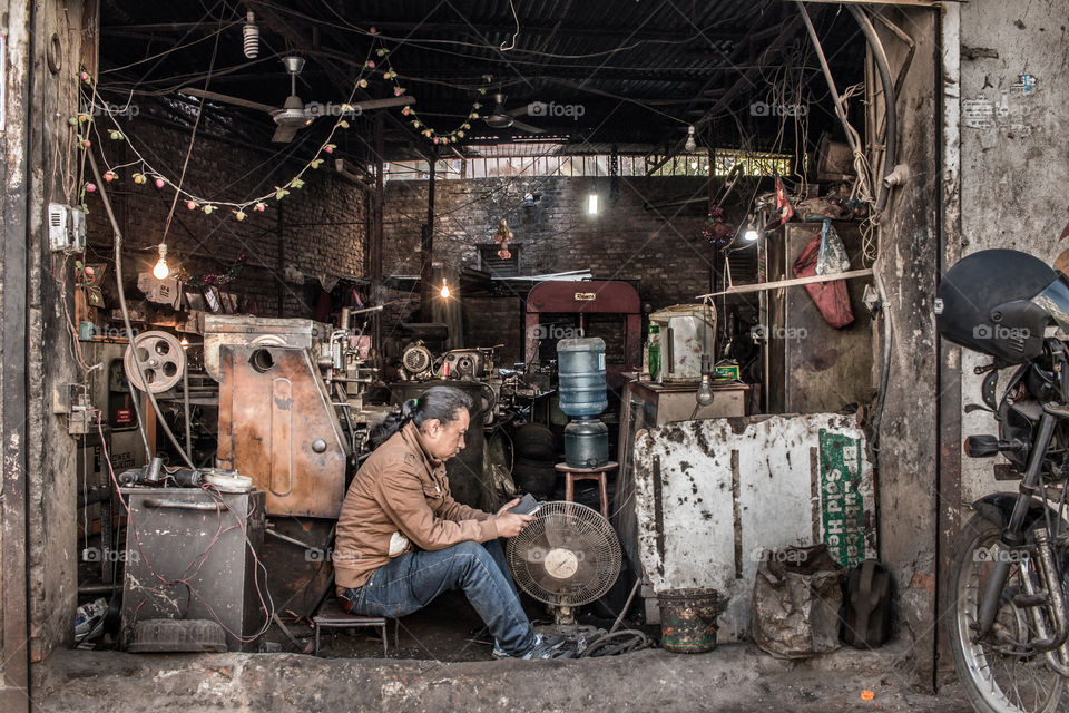 Nepalese iron workshop, worker is having a break in his garage.