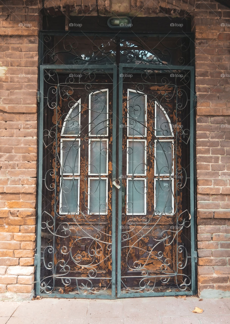 old vintage doors with cracked brown paint and bars
