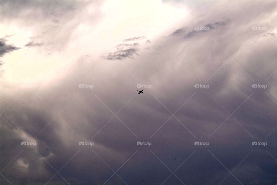 Plane soars through an ocean cloudscape.