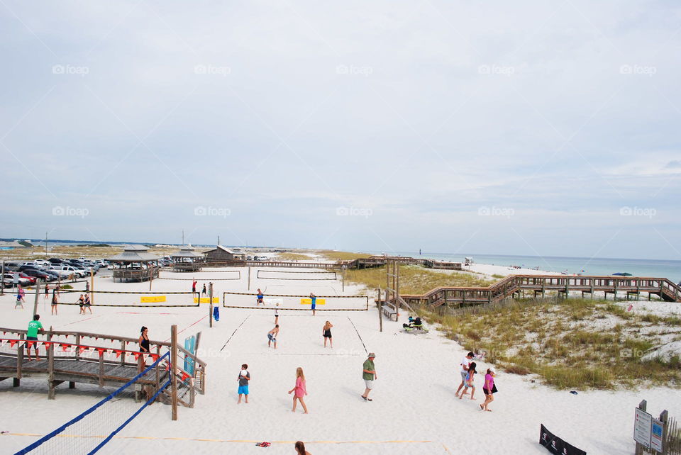 Many people playing volleyball at the beach in Florida