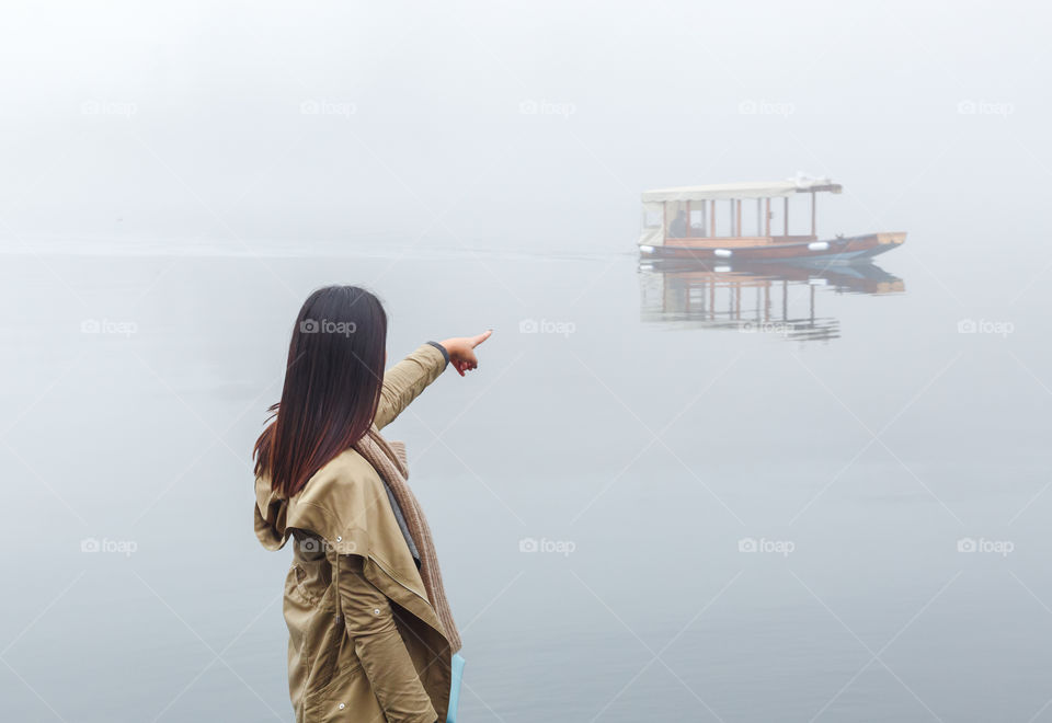 Woman standing at the entrance of temple holding umbrella