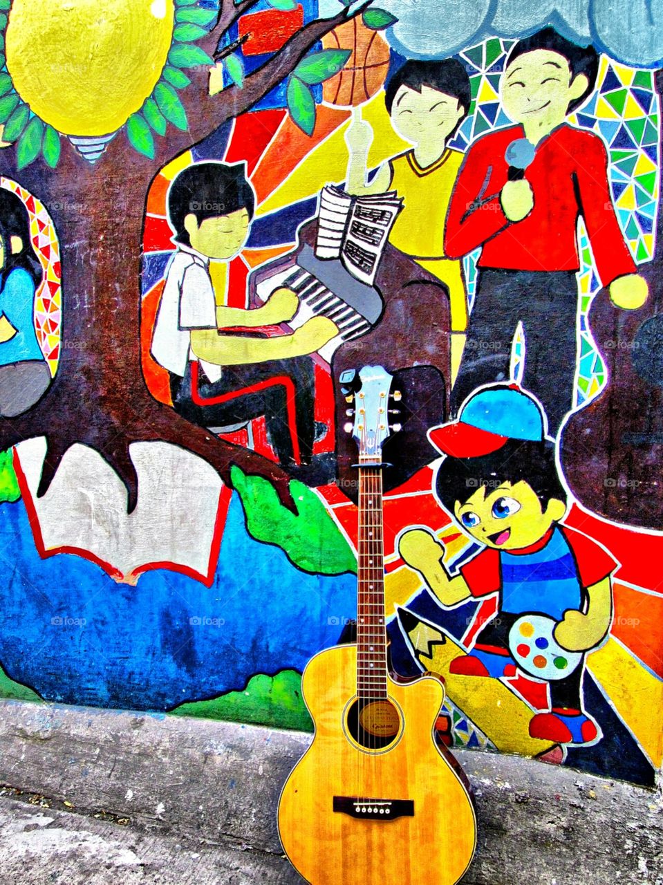 Guitar behind colorful wall