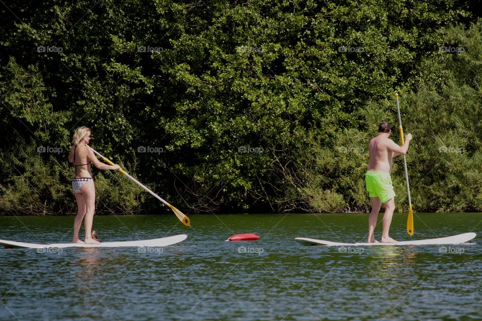 Couple On Stand Paddle Boards