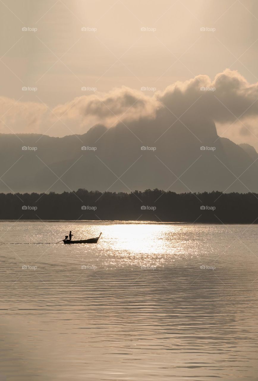 Beautiful Sunrise moment above silhouette of boat in sea