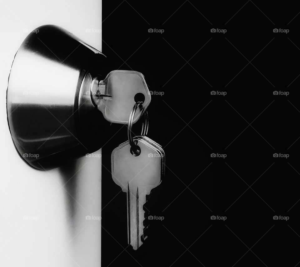 A lock and keys opening a white door into a black space