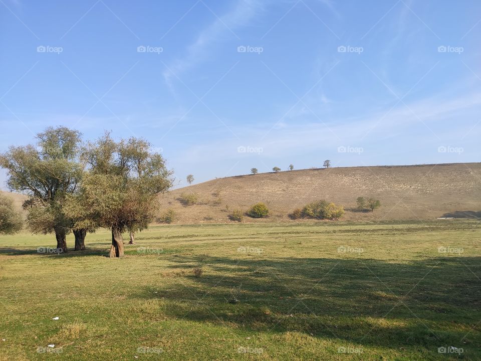 Field and trees and hills in distance Titel hill Serbia