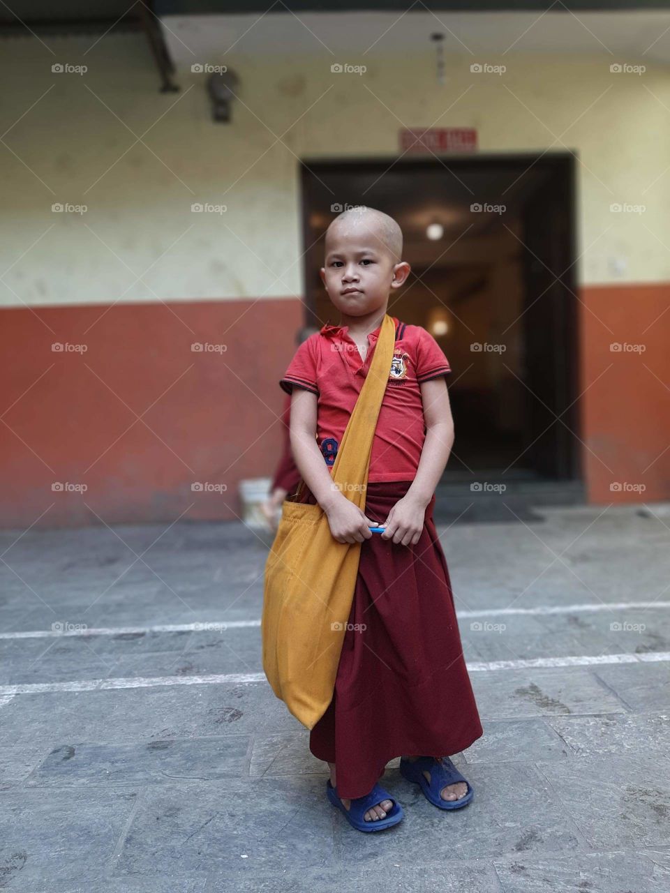 A little monk on the way to his class.