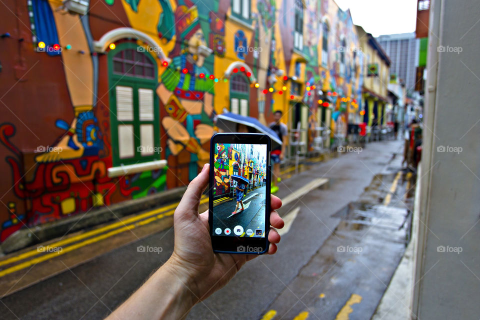 taking picture with mobile phone of colorful street in Hajib lane in Singapore