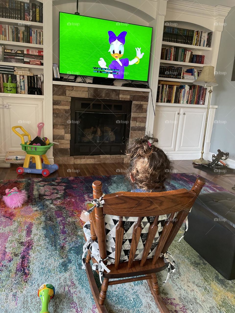 Toddler girl in rocking chair watching Daisy Duck, toddler watching Mickey Mouse movie, toddler in rocking chair watching TV, toddler watches a movie from a rocking chair