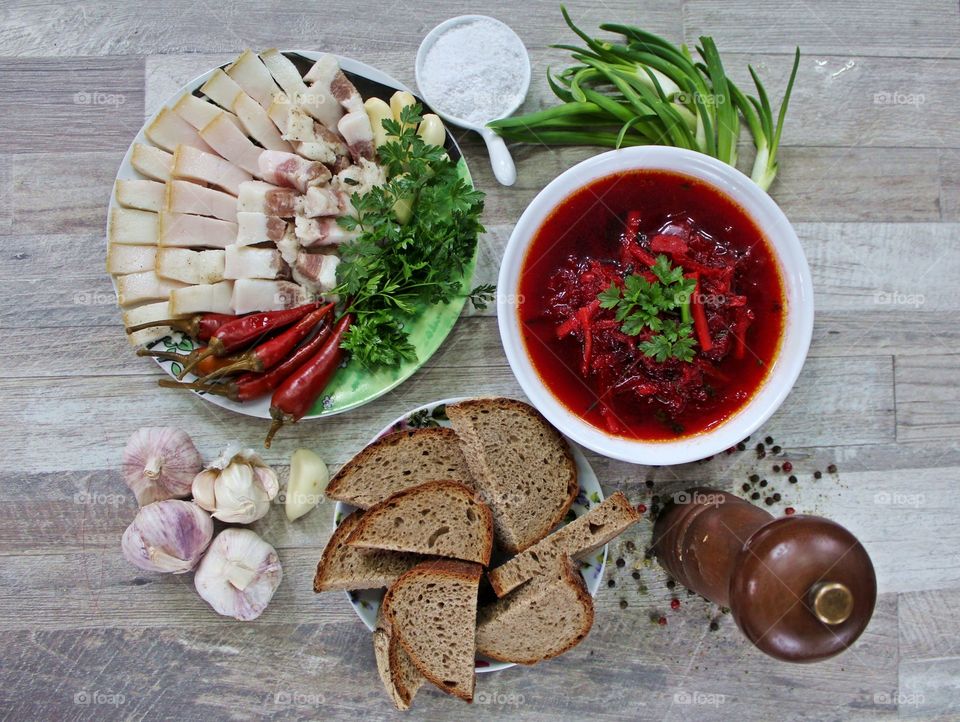 Beetroot soup (Ukrainian borsch) with bread, lard, garlic and greens.