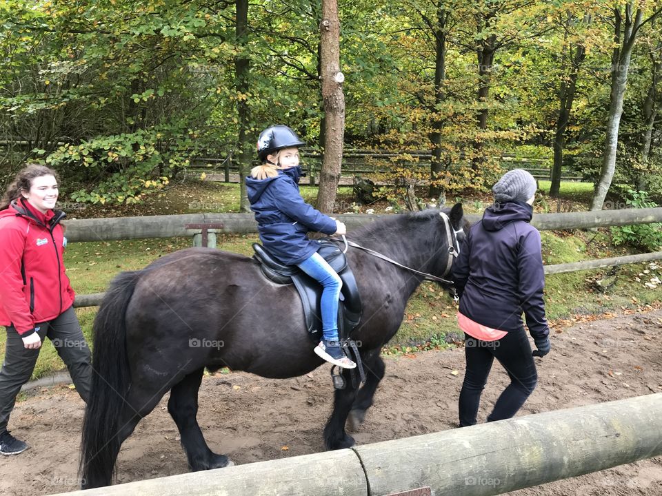 Young girl enjoying riding a horse