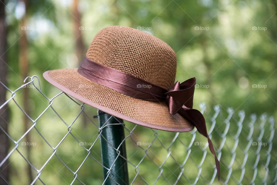 Brown retro hat in metal fence