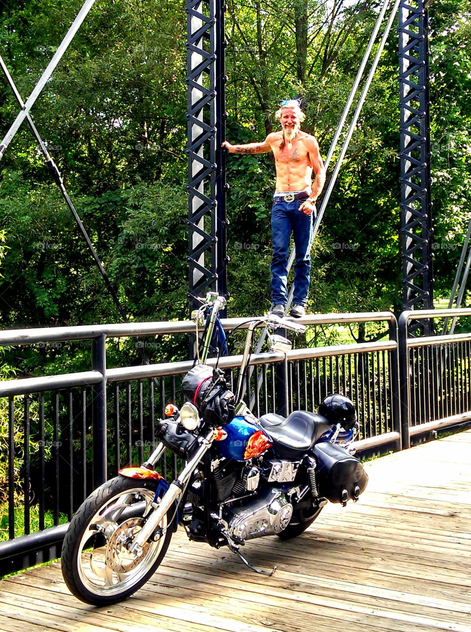 Shirtless man standing on railing near motorbike