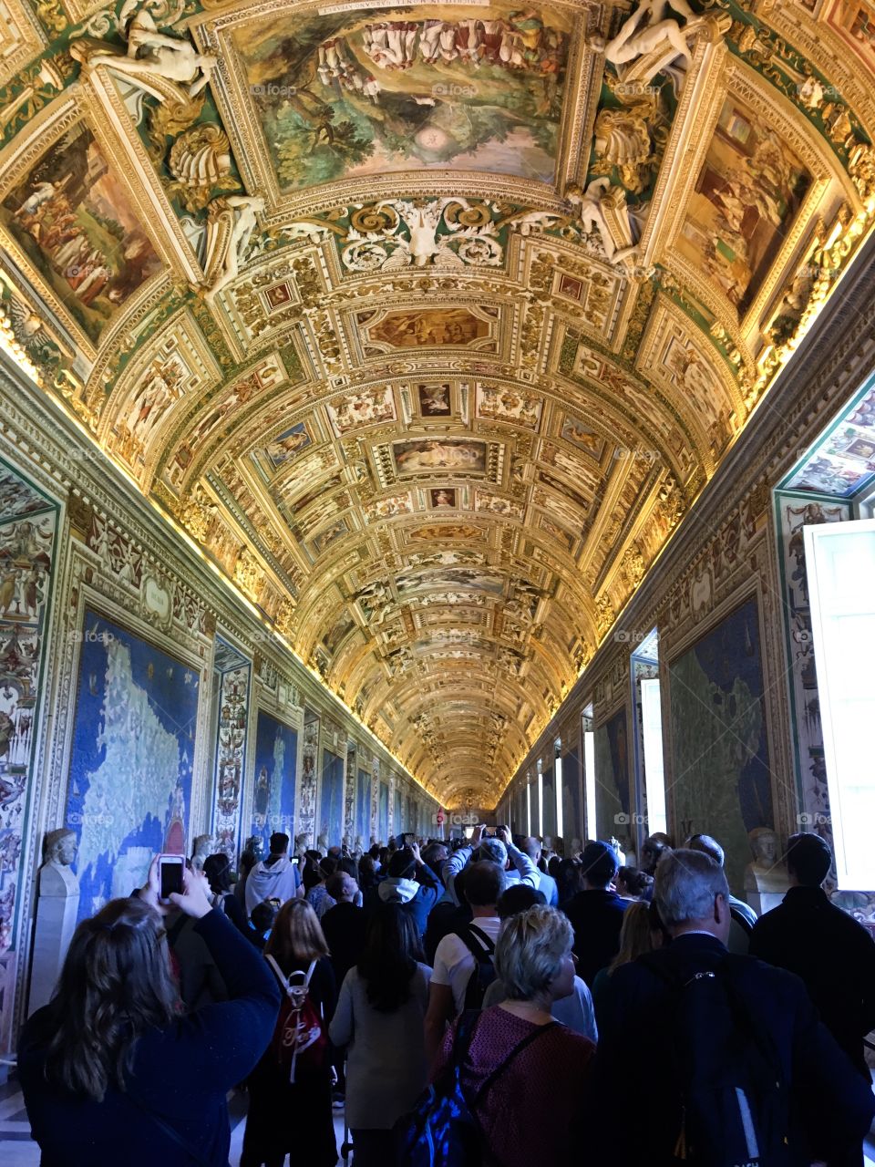 The hall of geographic map in Vatican museum. A crowd of people in museum. 