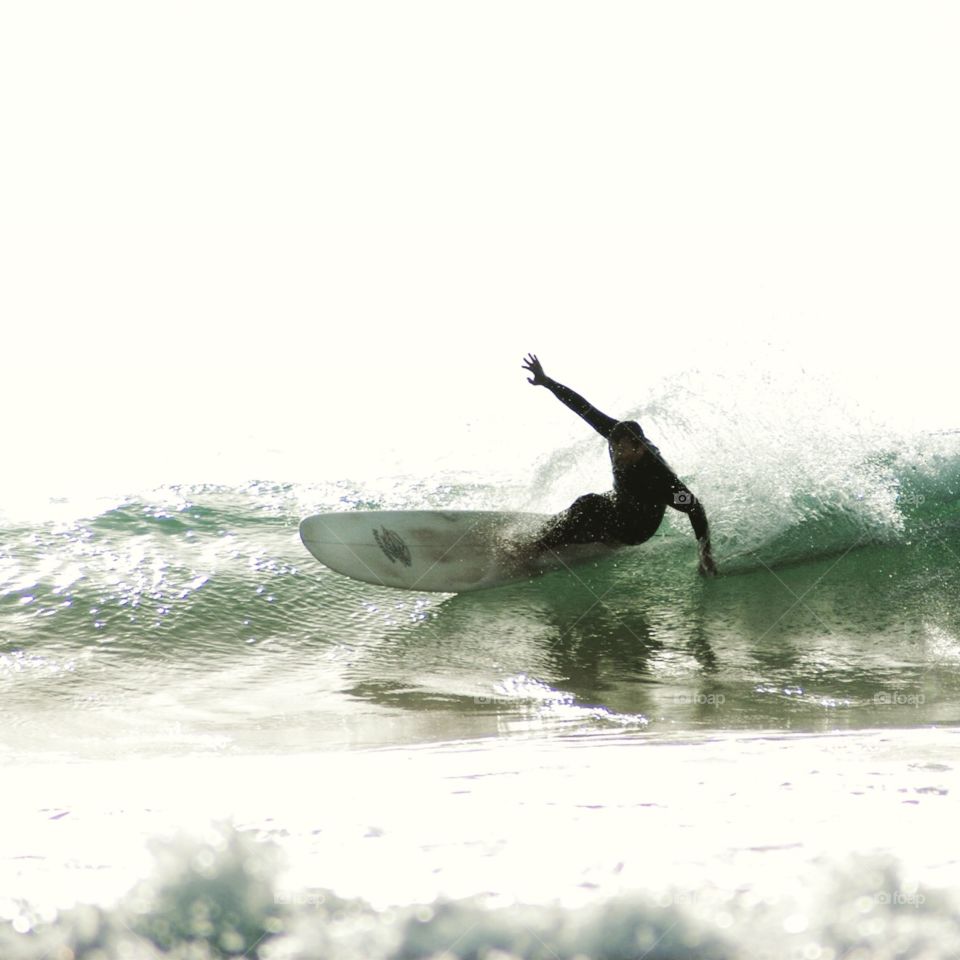 Longboard surfer on a wave. Longboard surfer carving down a wave