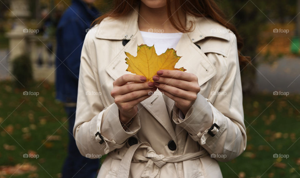 Girl hold a yellow leaf, autumn, men is looking