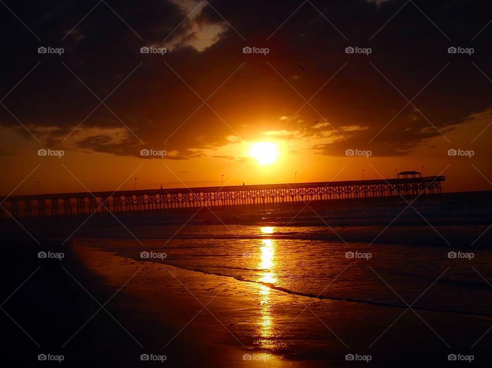 Sunrise over the Pier . A beautiful sunrise happening behind the pier in South Carolina. 