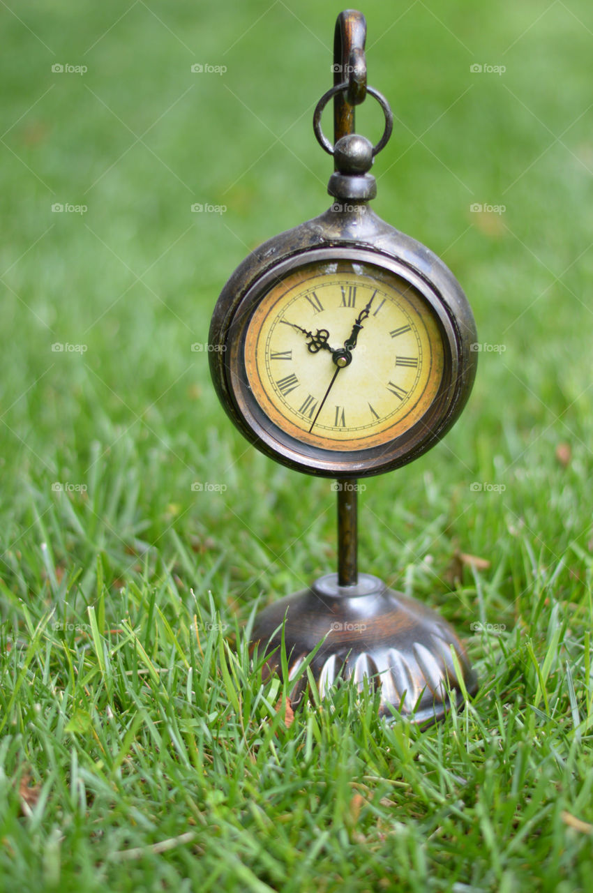 clock outside on the grass