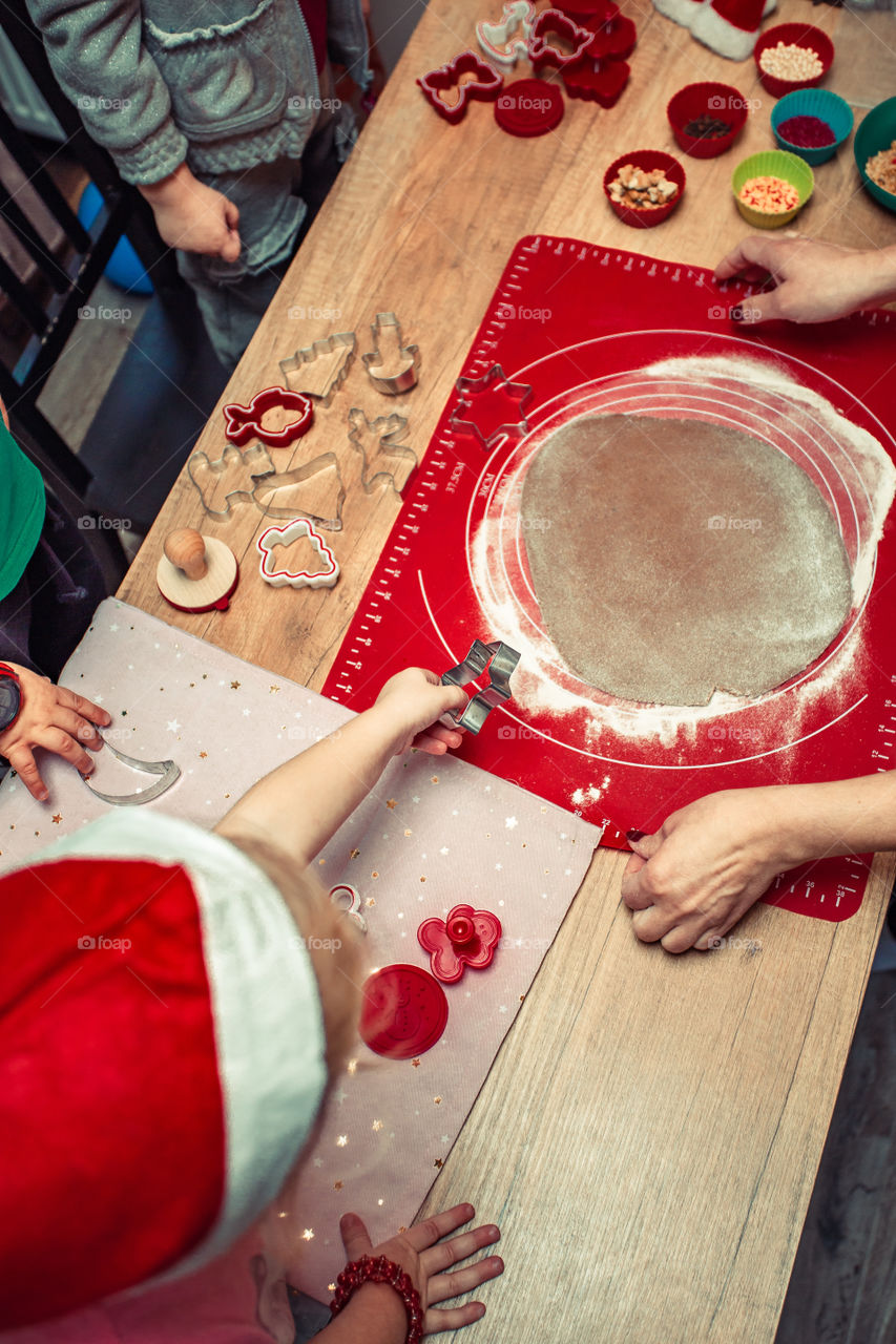 Baking Christmas cookies. Christmas gingerbread cookies in many shapes decorated with colorful frosting, sprinkle, icing, chocolate coating, toppers, put on table. Baking traditional cookies. Family celebrating Christmas. Baking at home
