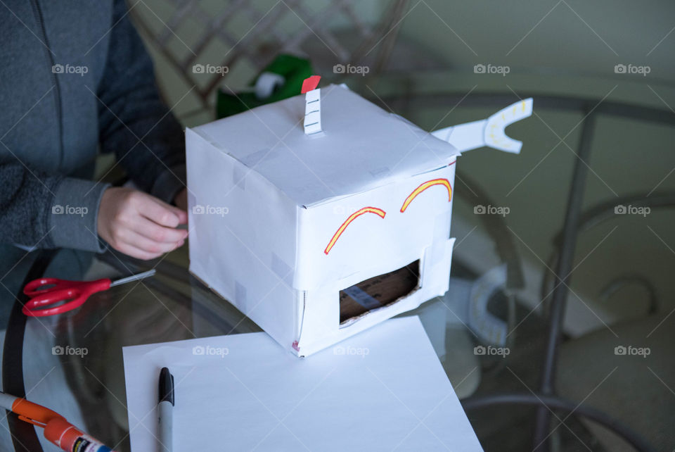 Young child making a cardboard robot