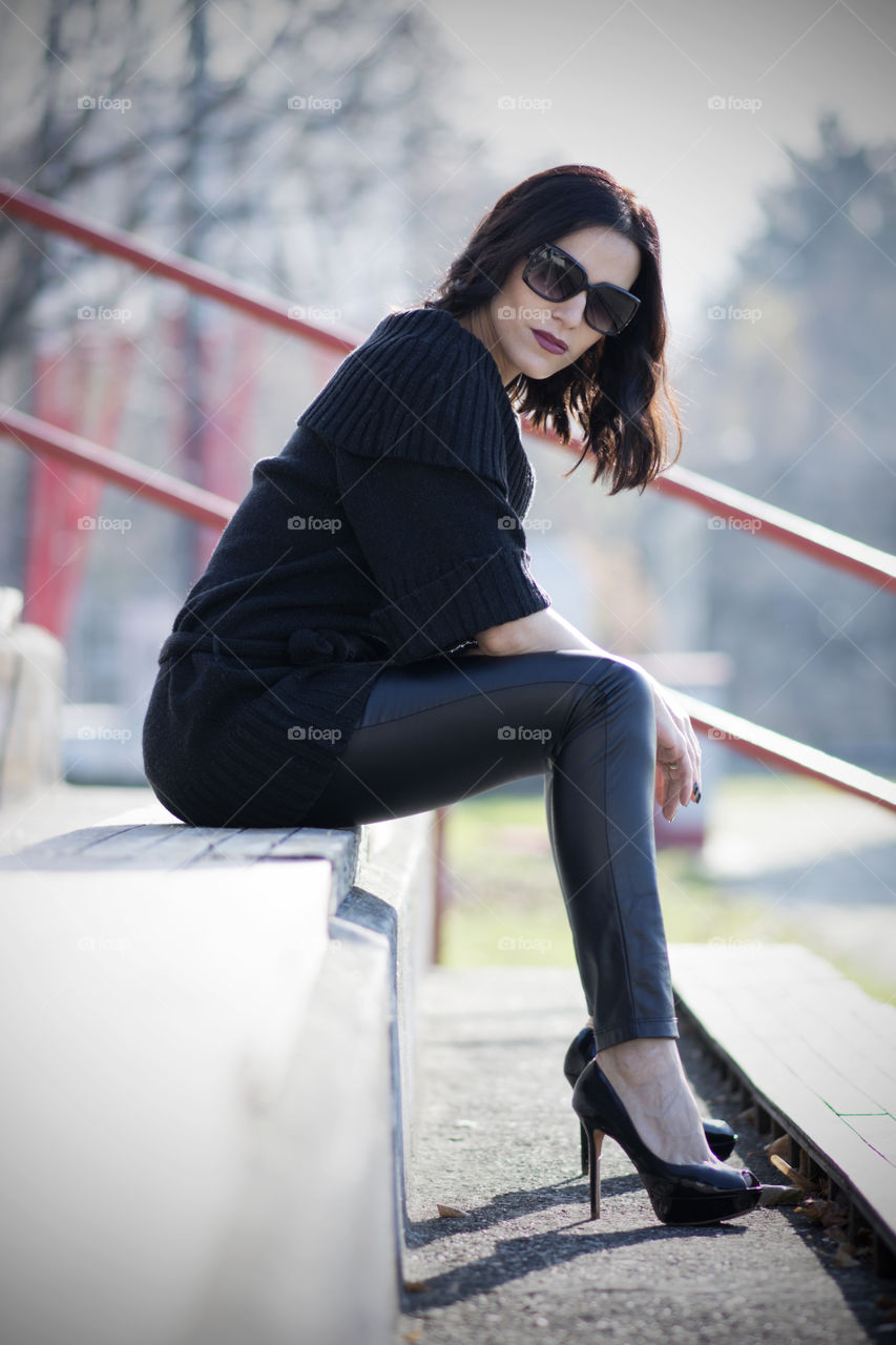 Side view of a elegant woman in high heels sitting