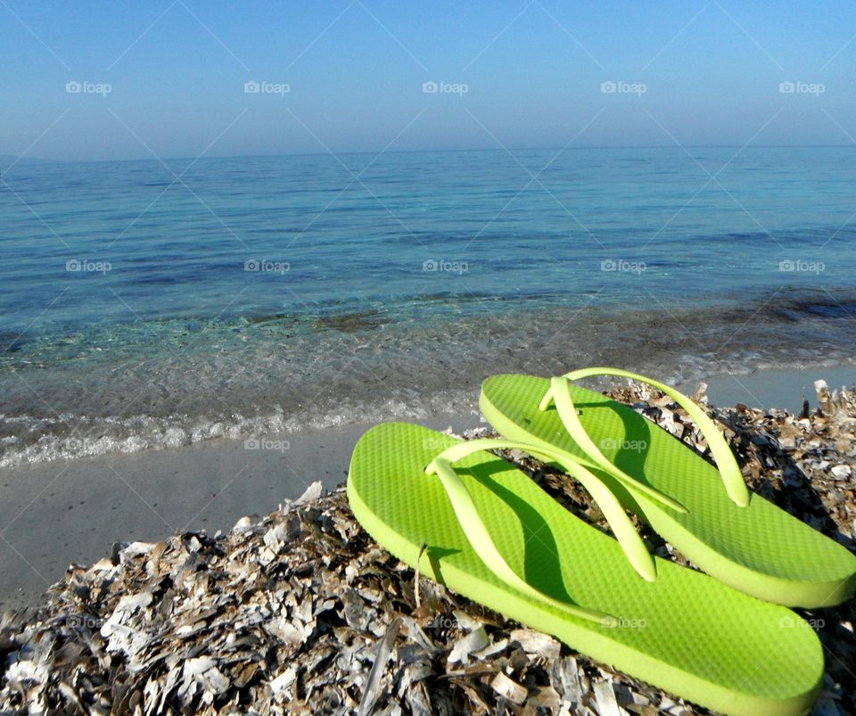 Pair of green flip flop at beach