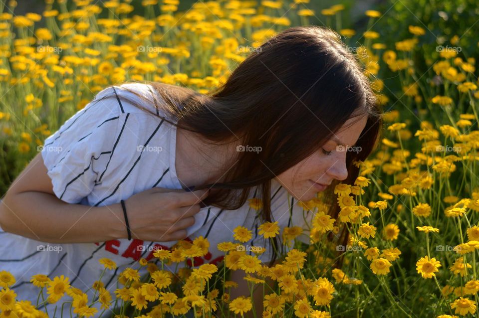 girl smeling flowers.