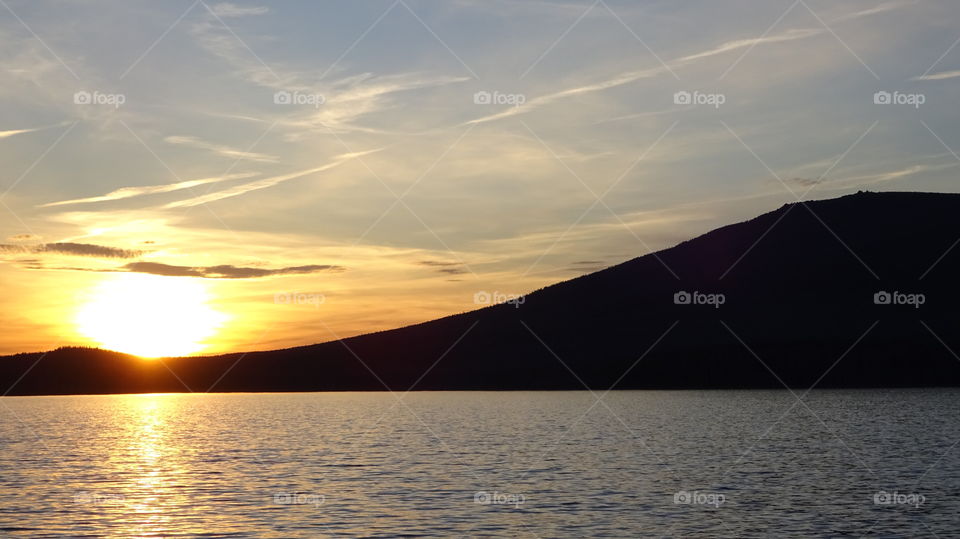 sunset on a reservoir and mountains in the Urals in Russia