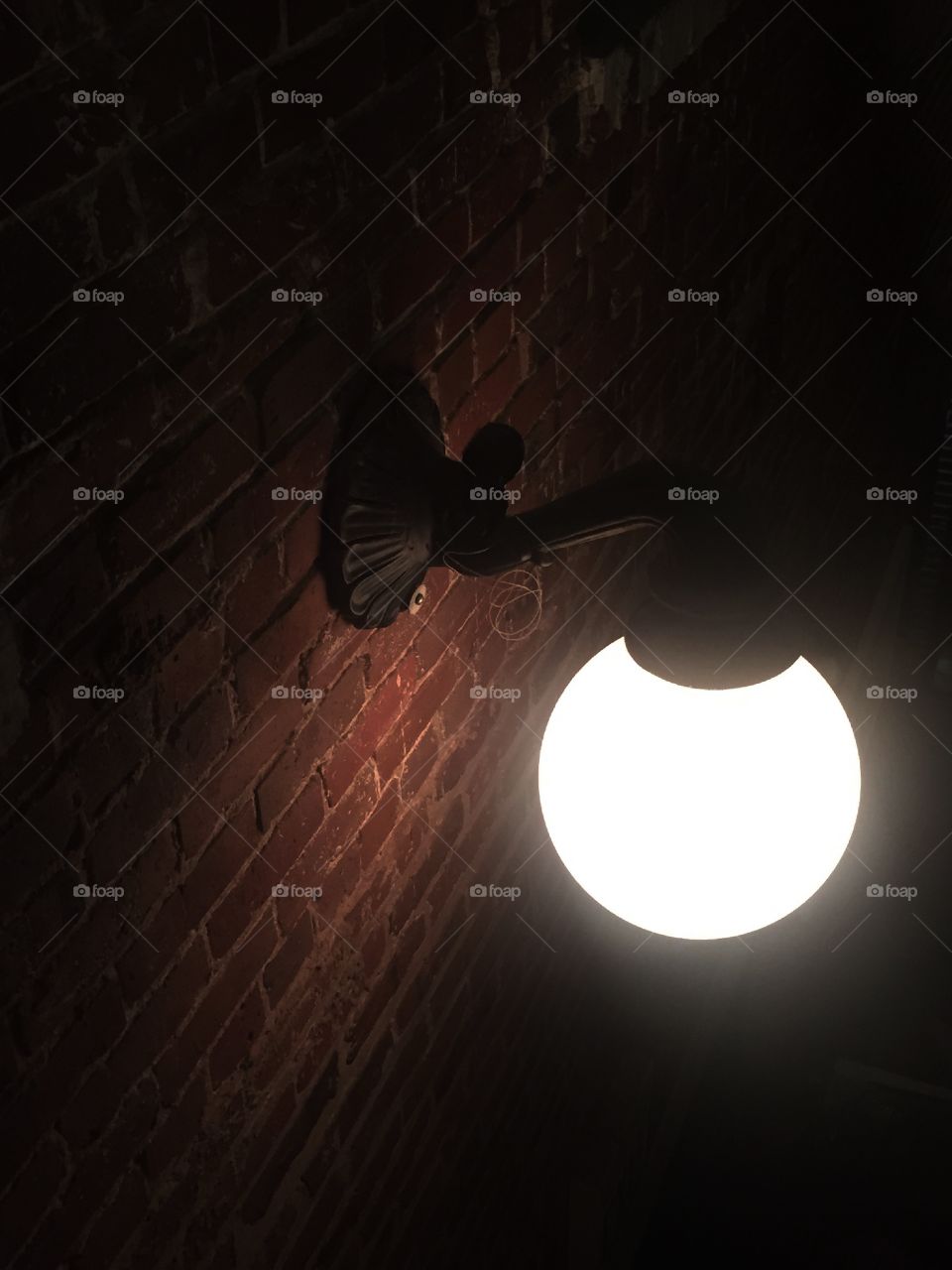 Illuminating brick. Inside of old brick building with old lamp light 