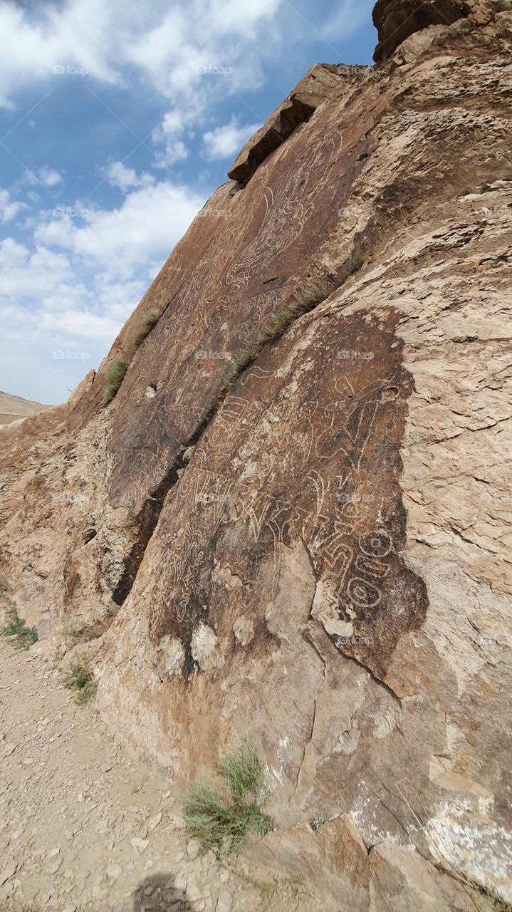 wall with ancient writings and Buddah in Tamgaly tas