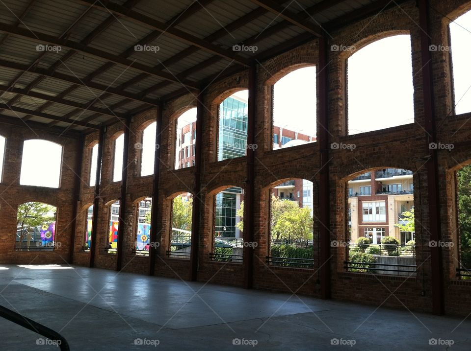 City scene viewed through rows of arched windows of a historic brick building.