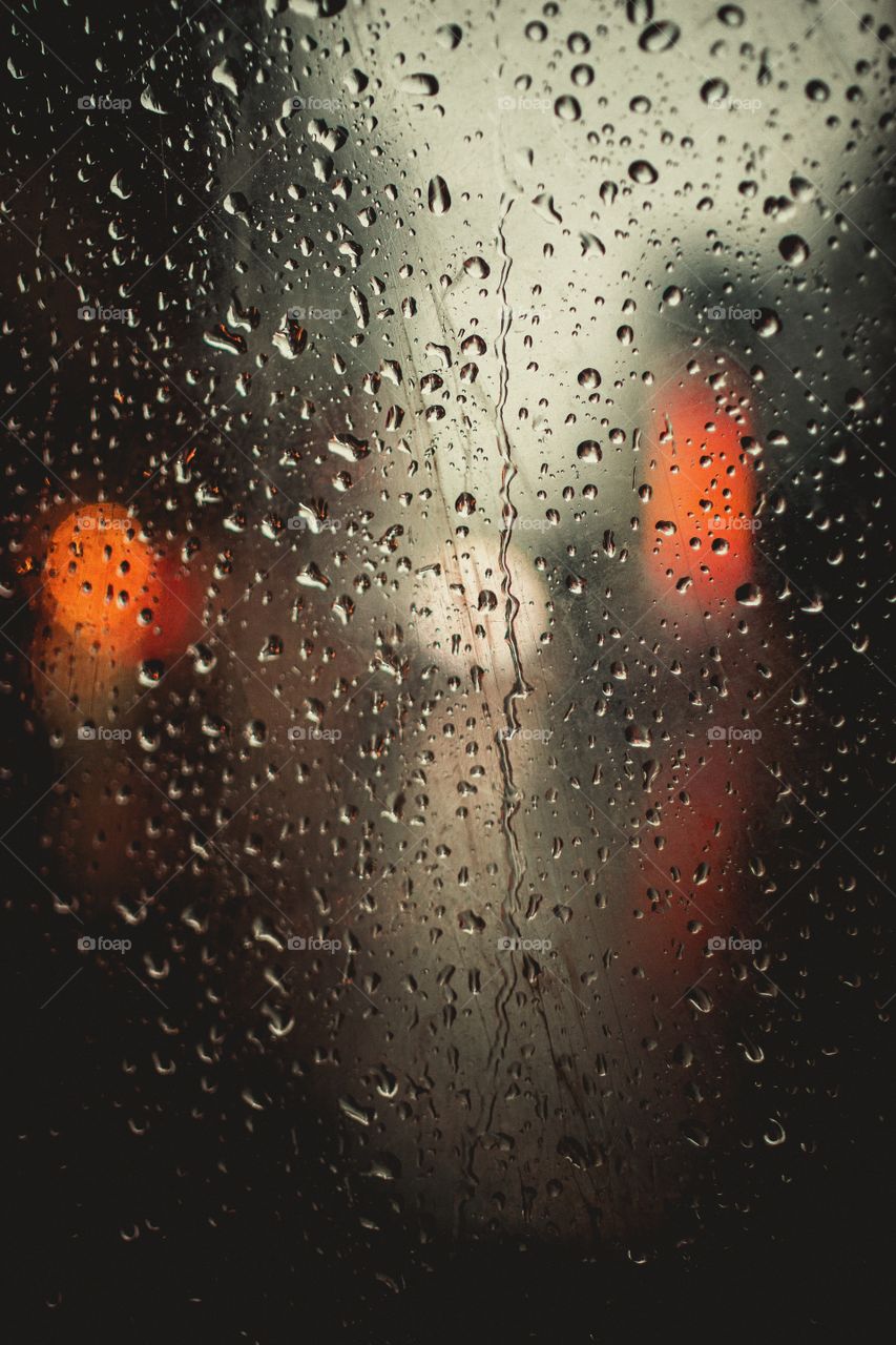 the light of the lights in the rain through the glass